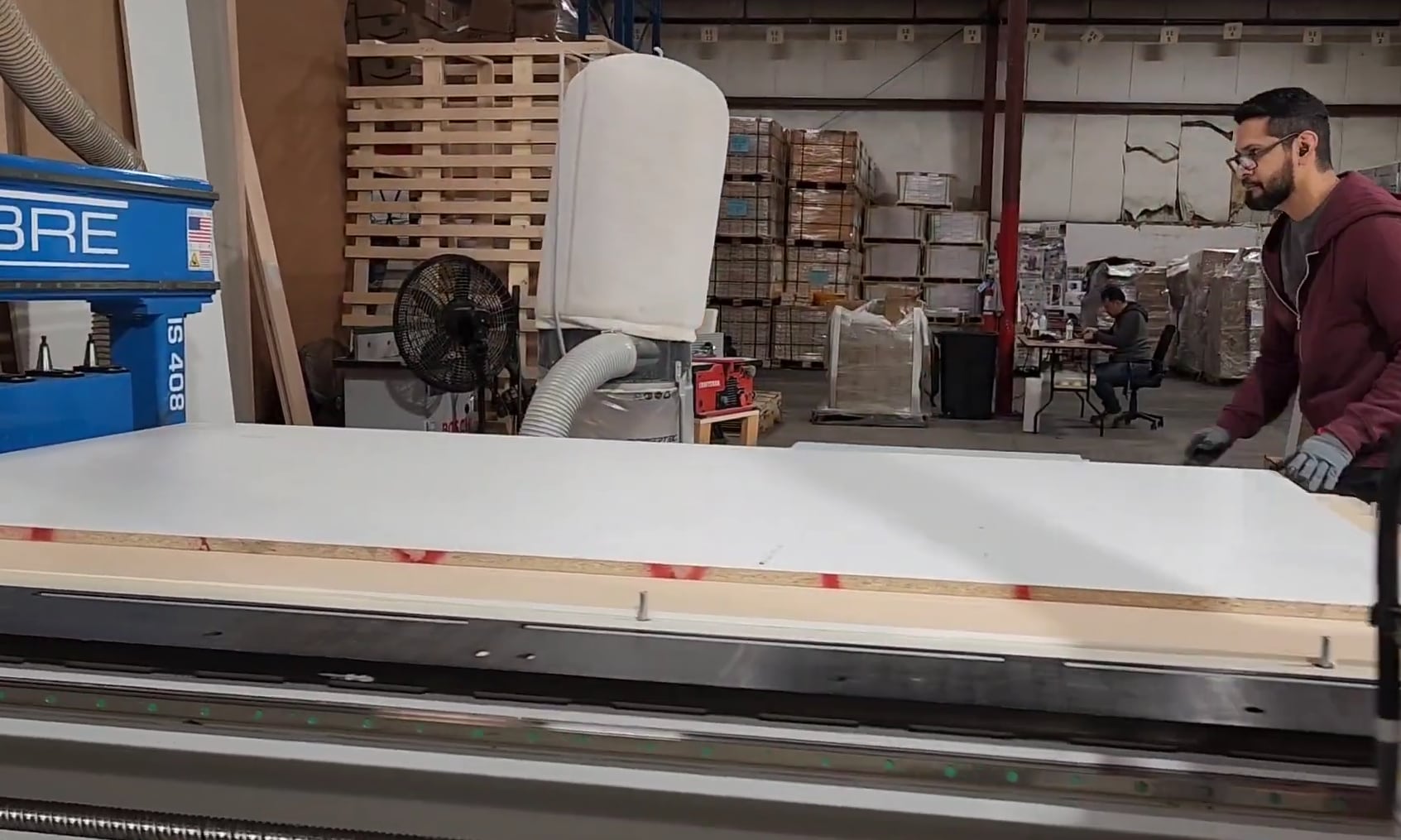 A cabinet panel being loaded onto a CNC cutting table