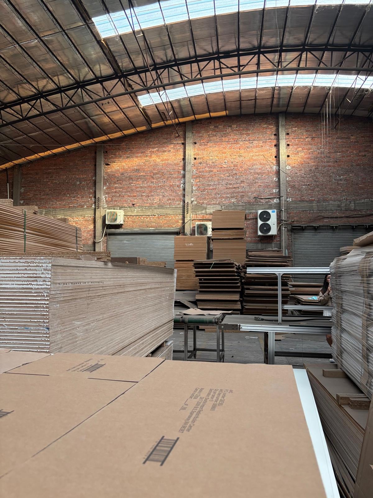Full sheets of decorative panel material stacked in the factory