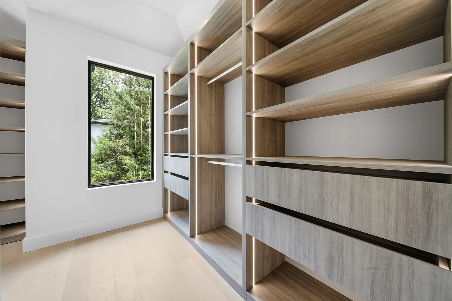 A white walk-in with oak shelving either side of a window
